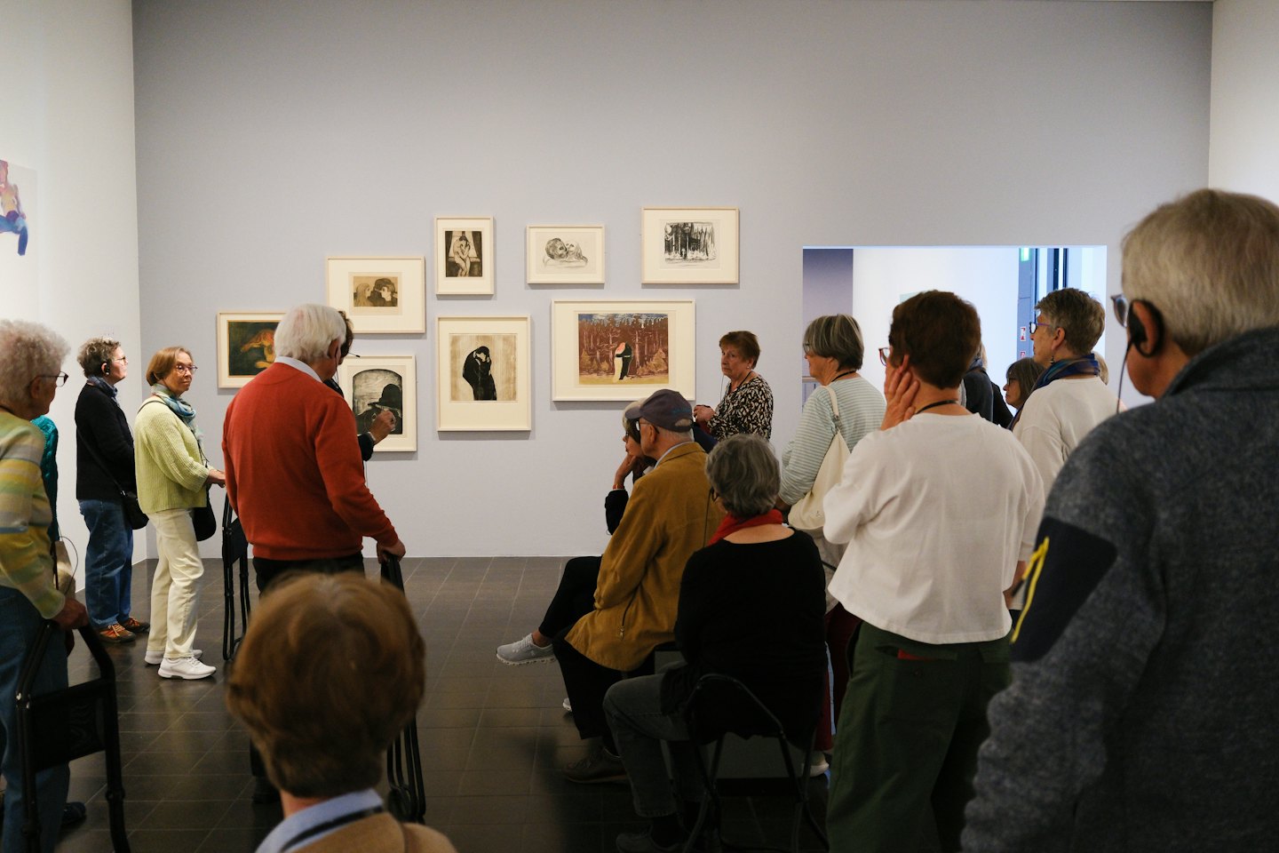 Des clients âgés examinent des œuvres d'art dans une galerie de musée.