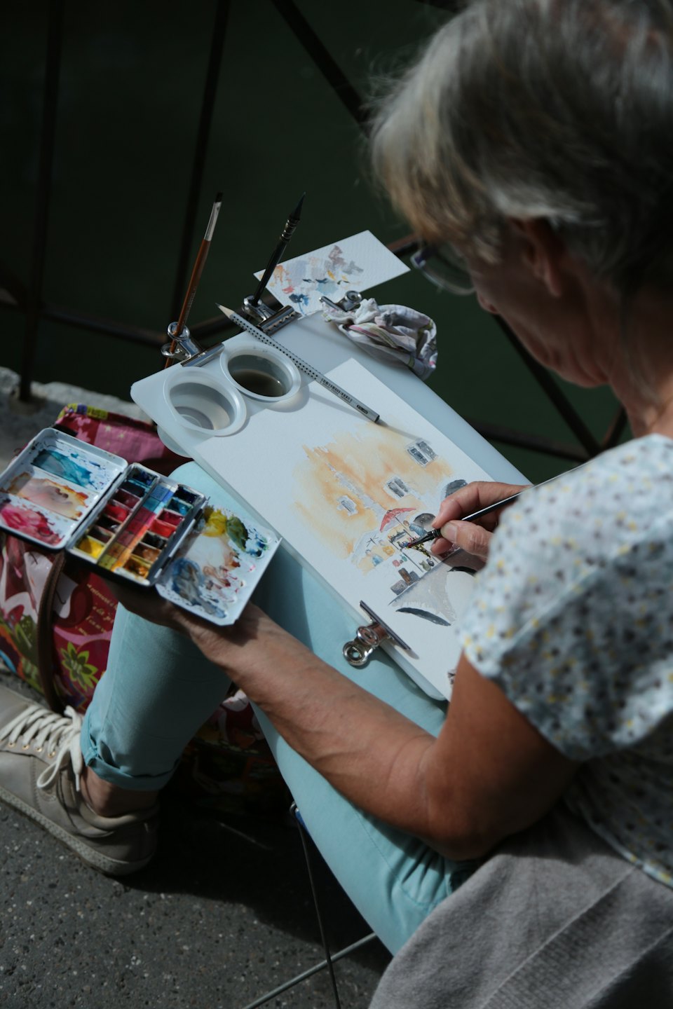 Femme peignant une aquarelle sur un presse-papiers portable.